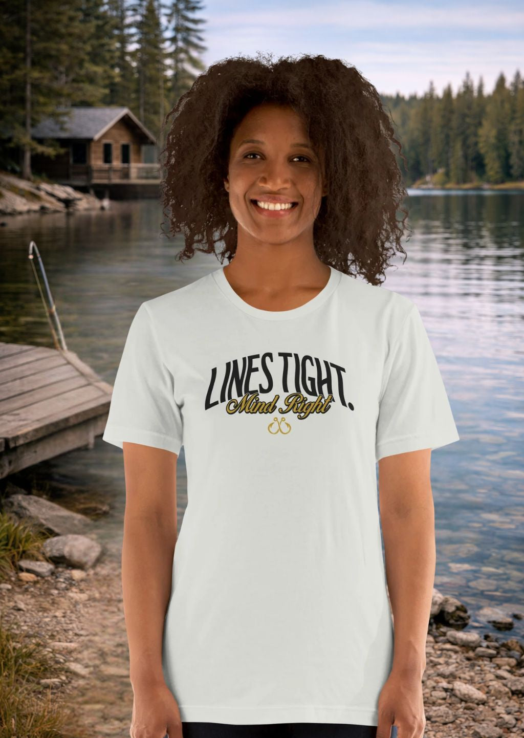 Person wearing a Fishing white t-shirt with 'LINES TIGHT Mind Right' text by a lake with a cabin in the background
